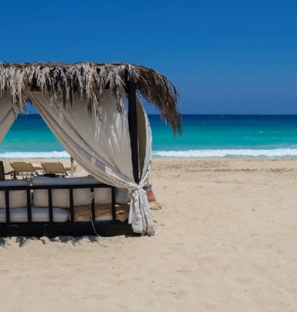 Ein eleganter Pavillon am Strand von Marsa Matruh in Ägypten mit türkisblauem, grün schimmerndem Mittelmeer und einer ruhigen, menschenleeren Küstenlandschaft.