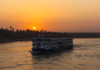 Nile cruise ship sailing past palm-lined banks at sunset on the Solar Eclipse Nile Cruise 2027