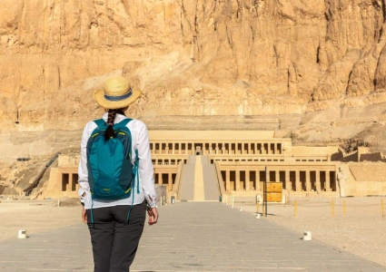 Woman in a straw hat looking at the Temple of Hatshepsut at Deir el-Bahari on the Luxor West Bank