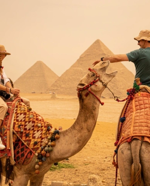 Adventurous Tourist Riding Camels by the Pyramids of Giza, Egypt Travel Packages