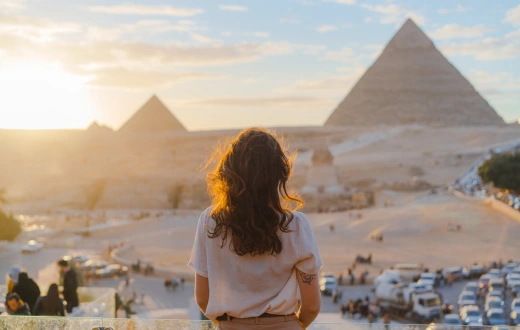 Woman standing on the terrace on the background of Giza pyramids