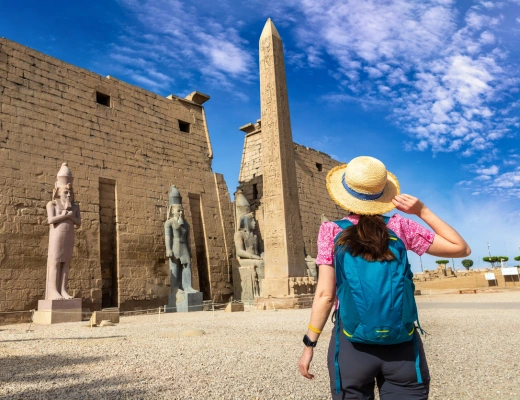 a woman wearing a hat in front of a temple in luxor, Cairo Luxor tour