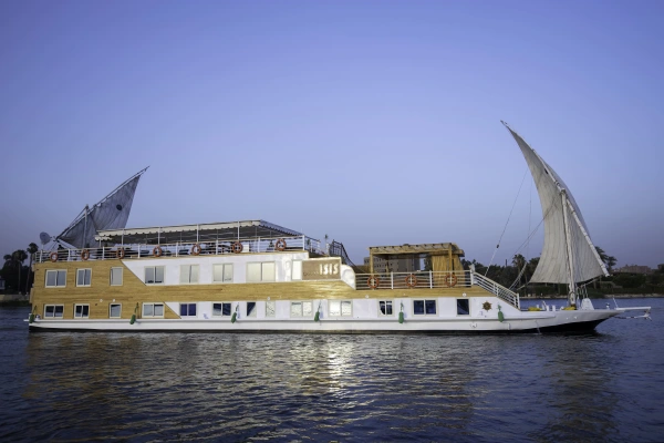 Dahabeya Queen Isis bei Dämmerung auf dem Nil mit beleuchteten Decks