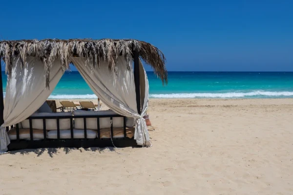 Ein eleganter Pavillon am Strand von Marsa Matruh in Ägypten mit türkisblauem, grün schimmerndem Mittelmeer und einer ruhigen, menschenleeren Küstenlandschaft.