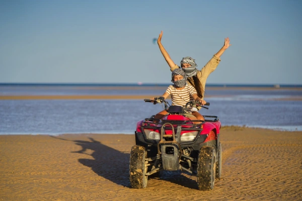Madre e bambino che si godono un'avventura in quad sulla spiaggia a Sharm el Sheikh.