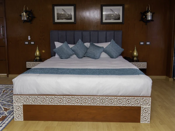 Doppelbett in einer Suite der Dahabeya Queen Isis mit Holzvertäfelung