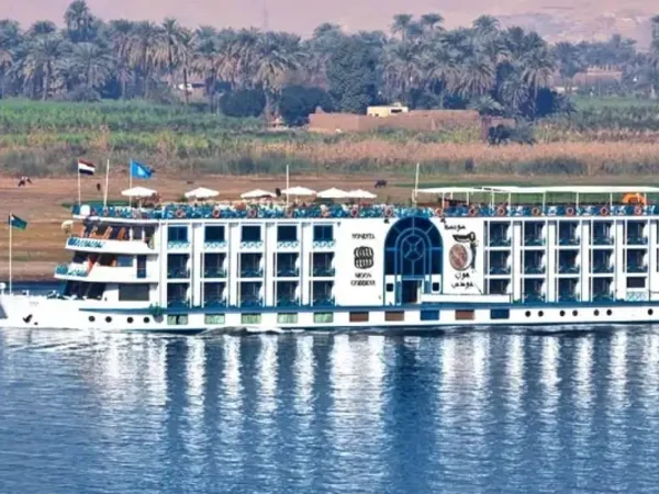 Das Nilkreuzfahrtschiff Sonesta Moon Goddess auf dem Nil mit Palmen am Ufer