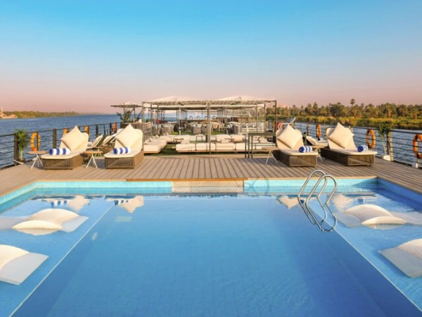 Pool auf dem Sonnendeck der MS Historia mit Liegen und Blick auf das Nilufer im Abendlicht