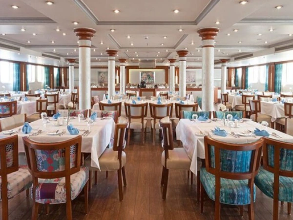 Restaurant an Bord eines Nilschiffs mit eingedeckten Tischen und weißen Säulen