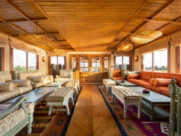 Gemütliche Lounge mit Sofas und Nilblick an Bord der Nonia Dahabiyya