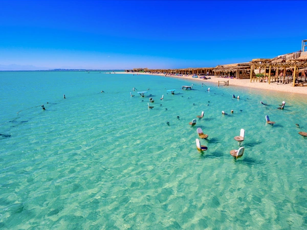 Luftaufnahme eines tropischen Strandes mit Stühlen im türkisfarbenen Wasser