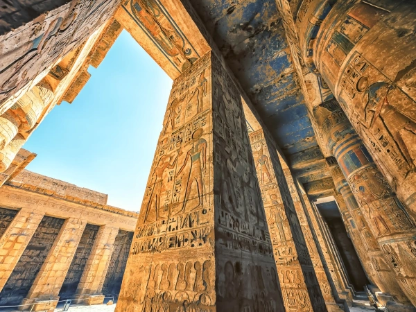 Blick auf kunstvoll verzierte Säulen mit farbigen Hieroglyphen in einem ägyptischen Tempel