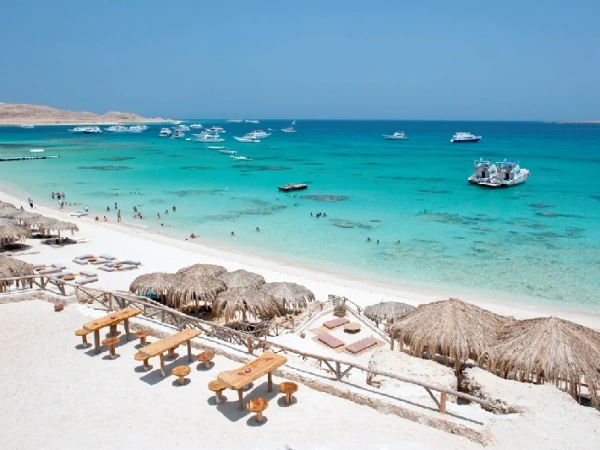 Luftaufnahme eines weißen Sandstrands mit Booten und türkisem Wasser