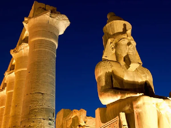 Beleuchteter Luxor-Tempel mit Statue von Ramses II. bei Nacht