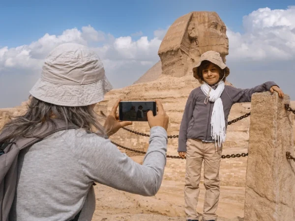 Kind wird vor der Großen Sphinx von Gizeh fotografiert