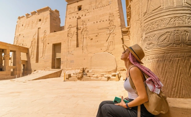 Woman sitting in Temple of Philae aka Temple of Isis in Aswan Egypt, Egypt Vacation Package