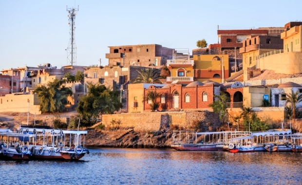 Wooden boats carrying passengers docked along the Nile River at the Temple of Philae in Aswan, Egypt Vacation Package