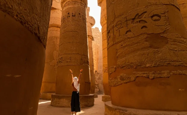 Turista caminando entre las columnas de la Gran Sala Hipóstila del Templo de Karnak , Viaje a Egipto Todo Incluido