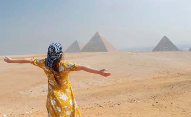 Vista trasera de una turista disfrutando de una visita a las Pirámides de Guiza, Egipto, viajes a el cairo todo incluido