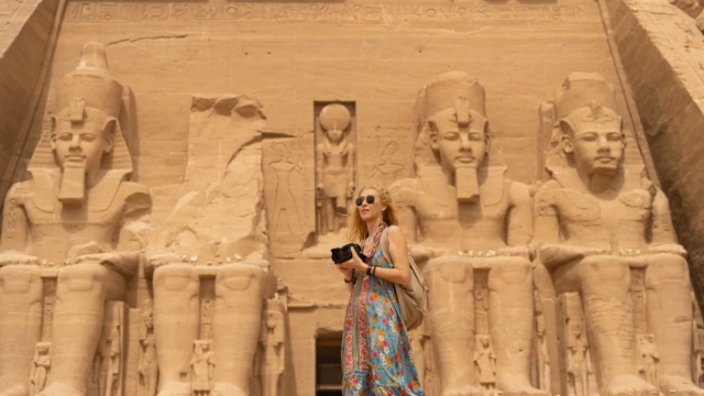 a woman standing infront of abu simble temple 