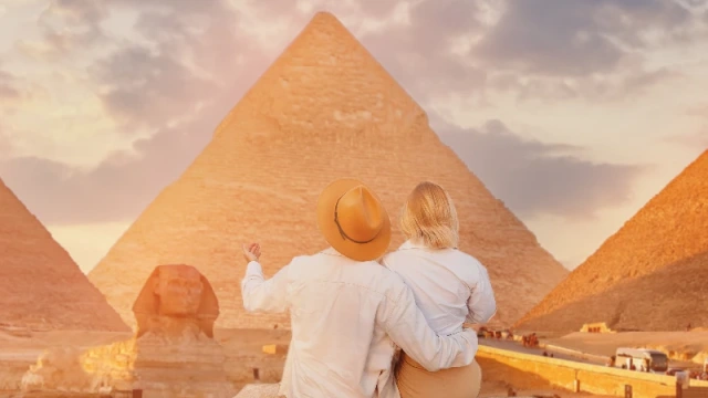 uomo e donna di fronte alle piramidi