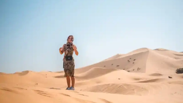 Una giovane donna cammina attraverso una duna di sabbia, Marrakech deserto agafay
