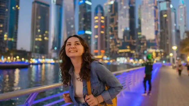 Donna che cammina a Dubai Marina al tramonto, attività a dubai