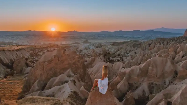 una donna al tramonto , camini delle fate cappadocia
