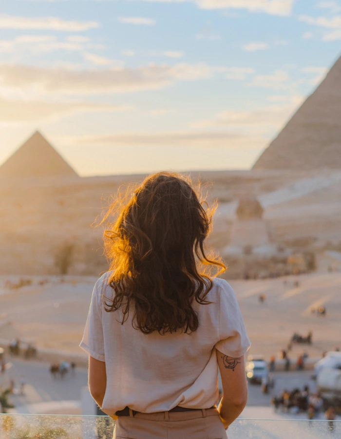 Woman standing on the terrace on the background of Giza pyramids