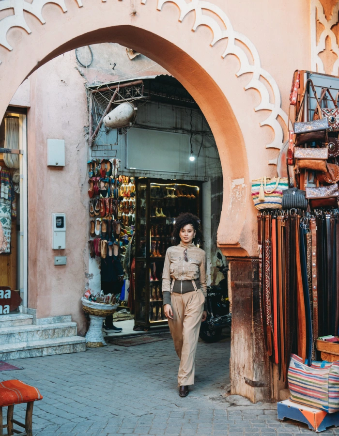 Young adult woman walking through an archway in Marrakech souk