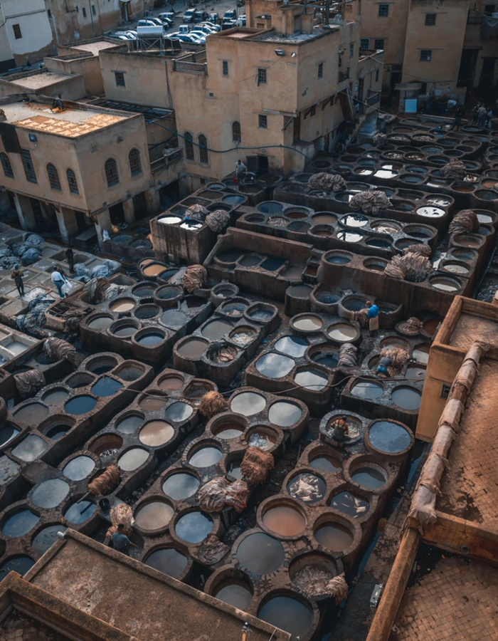 Men working at Chouwara Leather traditional tannery in ancient medina of Fes El Bali, Morocco, Africa.