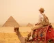 Pirámides de Guiza Una mujer turista montado un camello enfrente de las pirámides de Giza