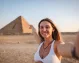una mujer turista tomando selfie enfrente de la Pirámide de Kefrén