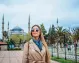 A Tourist with the Blue Mosque beautifully rising behind her.