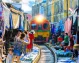 Maeklong Railway Market in Samut Songkhram, where vendors move their goods as the train passes.