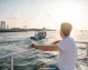 A man on a yacht enjoying the scenic views of Dubai Marina.