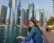 A happy traveler taking in the beautiful Dubai Marina scenery.