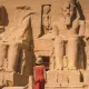 Una joven turista con vestido rojo entra al Templo de Abu Simbel, en el sur de Egipto, en Nubia, junto al lago Nasser. Templo del faraón Ramsés II.
