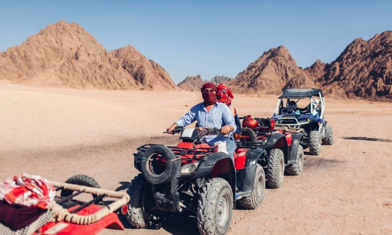Man and his daughter driving quad bike in Sinai desert, Desert Safari Egypt