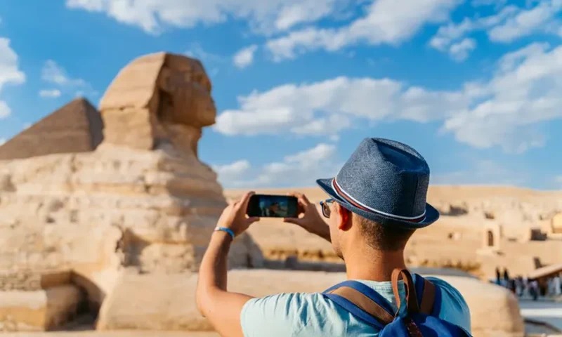Great Sphinx on the Giza Plateau with a pyramid rising in the background.