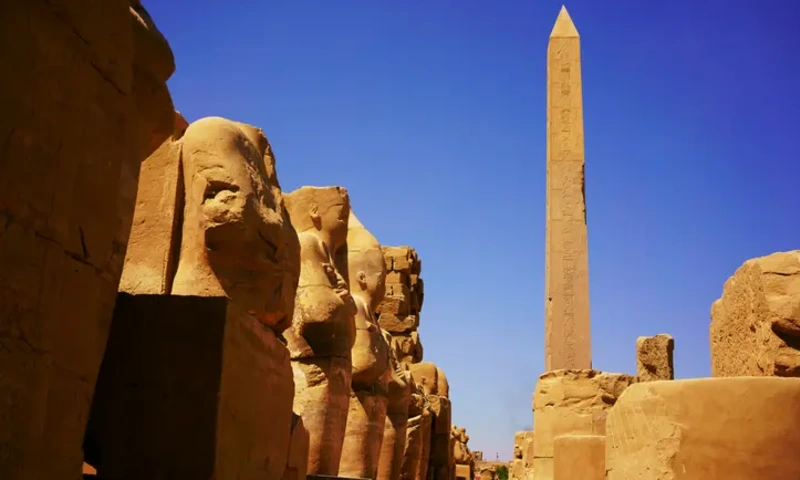 Hatshepsut’s tall stone obelisk rising above the ancient structures of the Karnak complex.