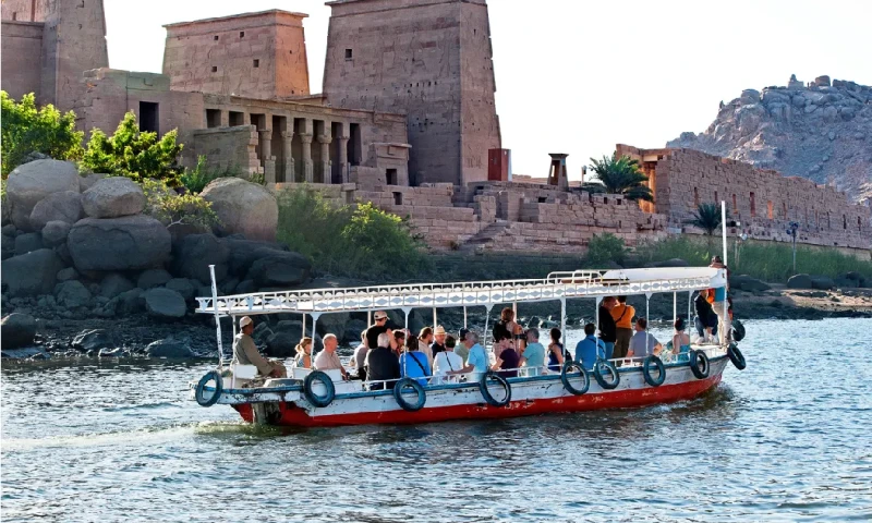 Barco turístico acercándose al Templo de Filae, Asuán, río Nilo, Aswan Egipto