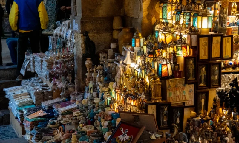 Un vendedor tradicional de jugo de regaliz sirviendo a niños locales en la calle Al-Muizz, El Cairo Egipto