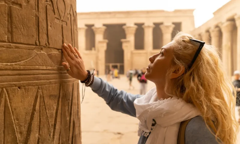 Turista tocando las columnas del Templo de Horus en Edfu,Templo de Edfu .