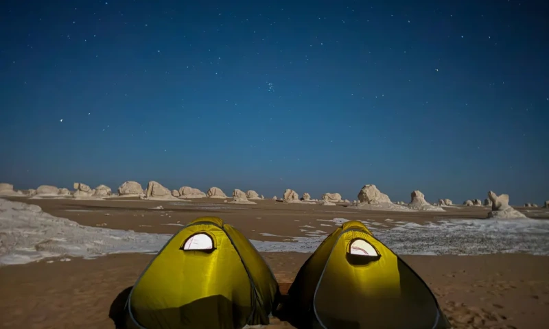 Dos tiendas de campaña en el desierto por la noche bajo un cielo estrellado en el Desierto Blanco, Oasis de Bahariya .
