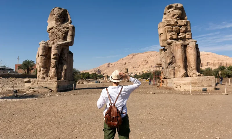 Turista visitando los Colosos de Memnón en Luxor, Colosos de Memnón .