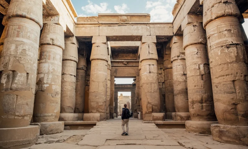 Man looking through walkway of Khonsu Temple at Karnak in Luxor, Visit Egypt