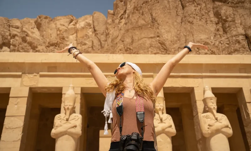 Turista con una cámara fotográfica frente al impresionante Templo de la Reina Hatshepsut en Luxor, Deir el Bahari.