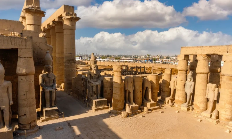 Templo de Luxor con antiguos vestigios egipcios bajo un cielo parcialmente nublado, Templo de Luxor.