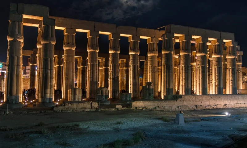 Templo de Luxor iluminado por la noche con turistas de visita, Templo de Luxor .